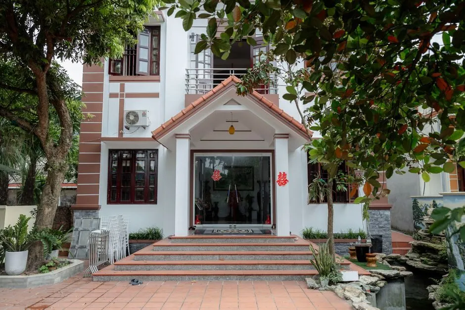 Ba chậu cây cao thấp sắp xếp ở sân trước nhà